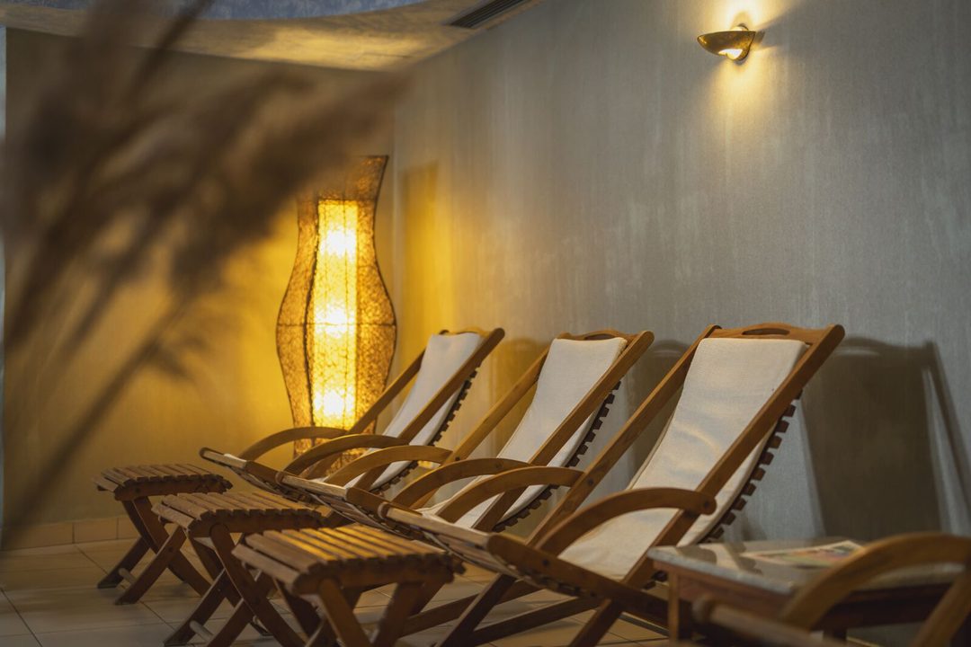 Fa nyugágyak a Tornácos wellness pihenőjében, meleg fényű lámpával