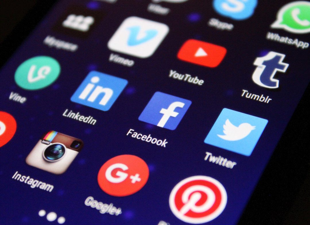 Okostelefon kijelzője közösségimédia-alkalmazások ikonjaival: Facebook, LinkedIn, Instagram, YouTube, Twitter