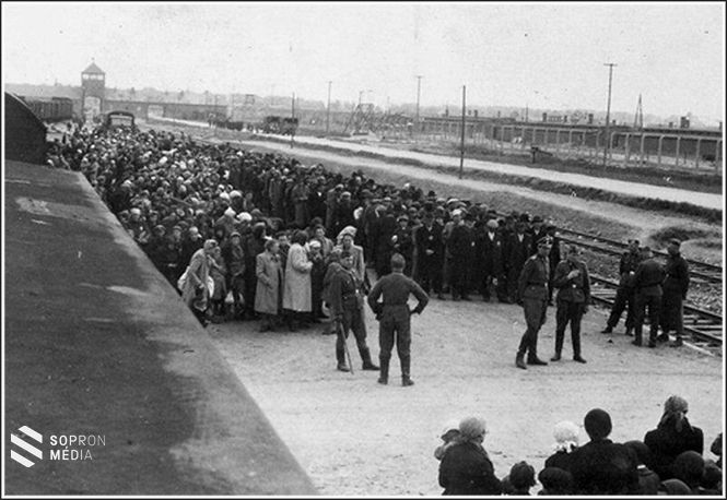 Magyar zsidó férfiak és nők szétválasztva a szelekcióra várakoznak. A kép előterében cigarettával dr. Josef Mengele.