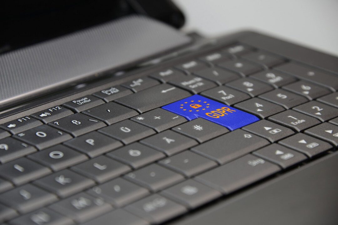 Laptop billentyűzete, rajta egy kék, uniós csillagokkal és lakattal díszített GDPR feliratú billentyű