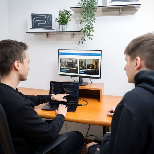 Két kolléga közösen dolgozik egy weboldalon az irodában