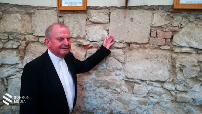 Németh Attila plébános mutatja a falba épített titokzatos, rendkívül régi köveket