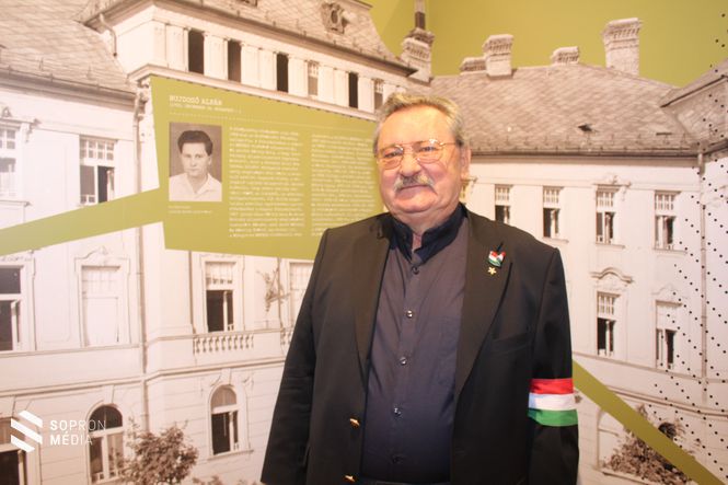 Bujdosó Alpár, a MEFESZ egykori elnöke saját fiatalkori fotója előtt áll a kiállításon.