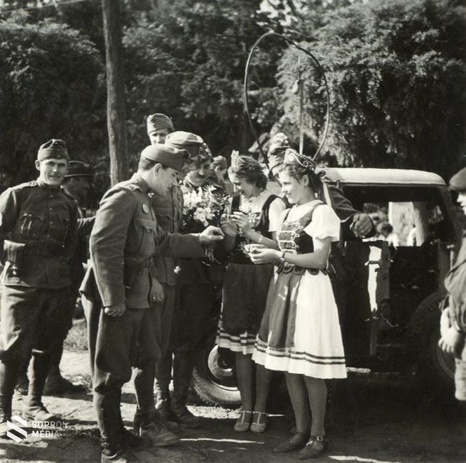 Híradós katonák és helybéli leányok a nagykárolyi Károlyi-kastély parkjának bejárata előtt.
