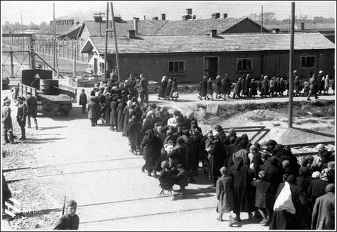 A munkaképtelenek menete a II. krematórium felé tart. A teherautón lévő hordóban Zyklon-B tartályok.