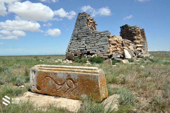 Állatfigurás faragott kő és az egyik építmény maradványa a rommezőn
