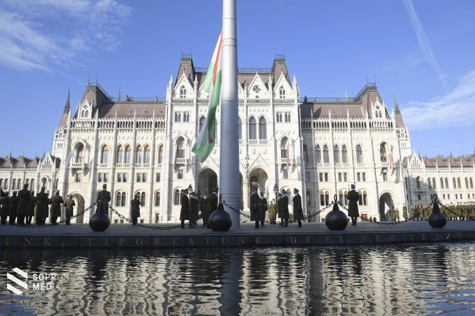 Budapest, 2018. november 4. Benkő Tibor honvédelmi miniszter jelenlétében katonai tiszteletadással felvonják, majd félárbócra engedik Magyarország lobogóját a Kossuth téren, a Parlament előtt az 1956-os forradalom és szabadságharc leverésének és a szovjet csapatok bevonulásának 62. évfordulóján, a nemzeti gyásznapon 2018. november 4-én. A kegyelet jeleként a lobogó egész nap félárbócon marad. 