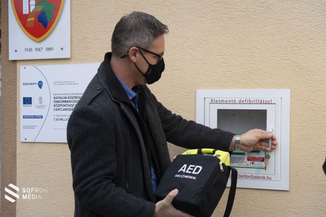 Duschanek Péter polgármester elhelyezi az életmentő berendezést.